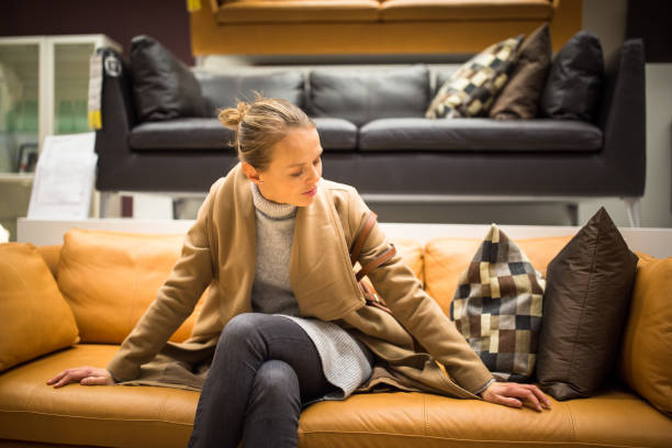 Pretty, young woman choosing the right furniture for her apartment stock photo