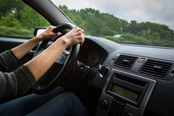 istock Male driver's hands driving a car on a highway 902156500