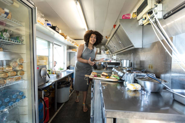istock Smiling female food van worker making sandiches 902157578