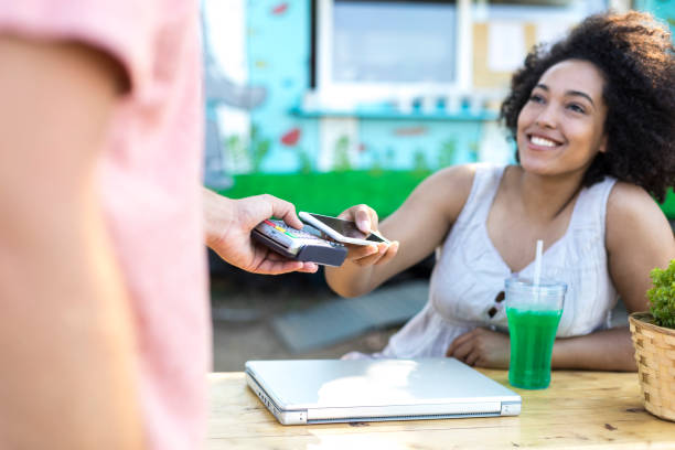 istock Woman drinking cocktail and using credit card 902157580
