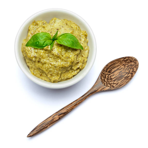 istock Pesto Sauce with Basil and wooden spoon on White Background Studio shot 902164562