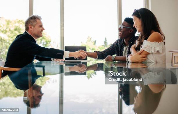 Estate Agent Congratulating Couple After A Property Deal Stock Photo - Download Image Now