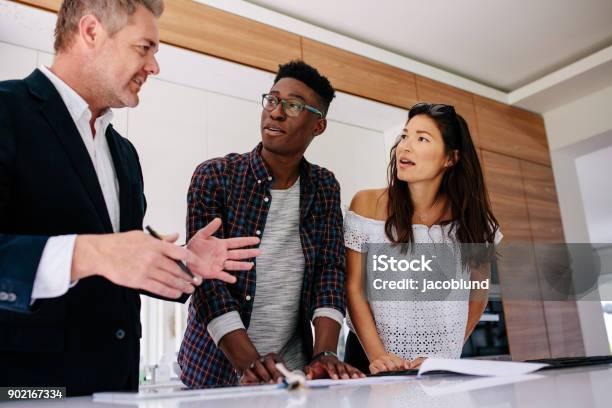 Interracial Couple Having Consultation With A Real Estate Agent Stock Photo - Download Image Now