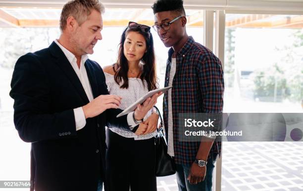 Real Estate Agent Sharing Property Details With Clients Stock Photo - Download Image Now