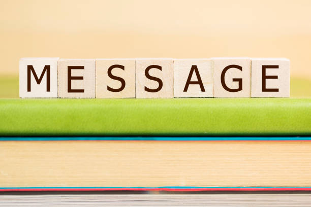 istock Message word built with letter cubes on green book 902170910