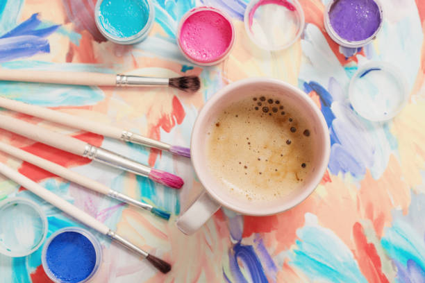 istock paints, brushes and cup of coffee on paper 902171814