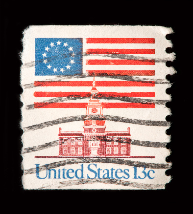 Image of USA flag and Philadelphia's Independence Hall Stamp with black background.