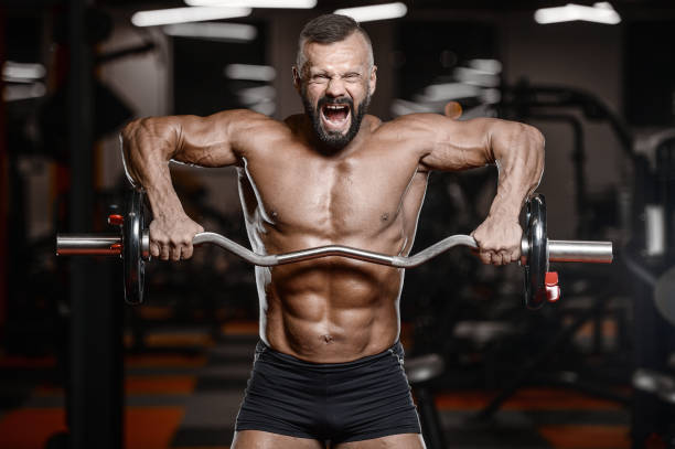 istock Old brutal strong bodybuilder athletic men pumping up muscles with dumbbells 902176464