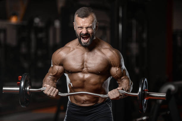 istock Old brutal strong bodybuilder athletic men pumping up muscles with dumbbells 902179580