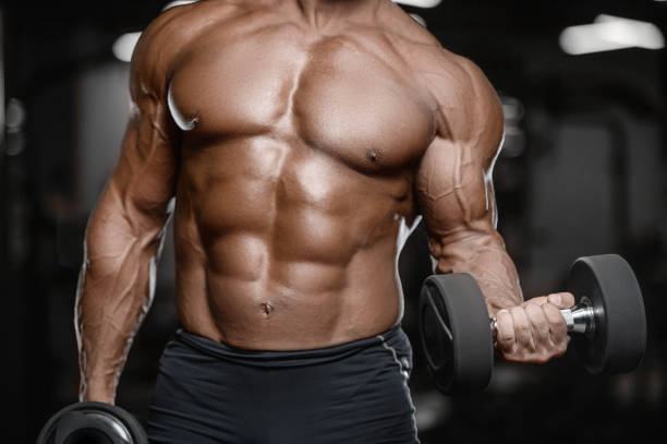 istock Old brutal strong bodybuilder athletic men pumping up muscles with dumbbells 902180558
