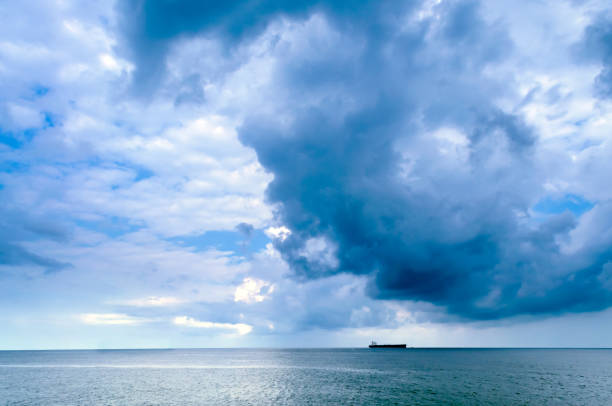 istock Lone ship in the sea with dark clouds looming over 902180950