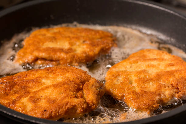 istock Frying wiener schnitzel in a hot pan 902183854