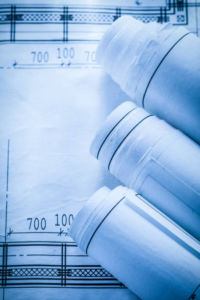 istock Rolled up construction drawings on blueprint top view 902188238
