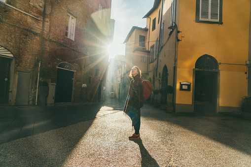 Young Caucasian woman walking on the streets of Lucca, Italy
