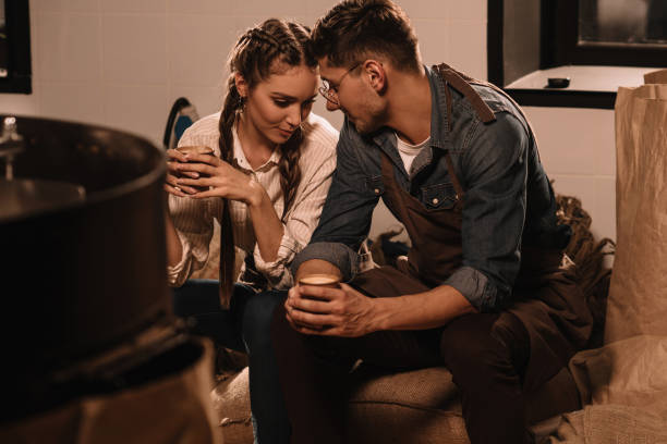 istock couple with cups of coffee having break during work 902195518