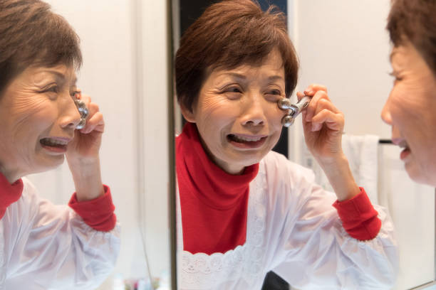 istock Japanese senior woman massaging her face 902195684