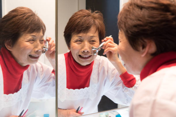 istock Japanese senior woman massaging her face 902196010