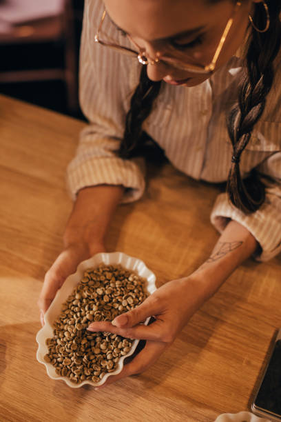 istock woman testing coffee beans in coffee shop 902199674