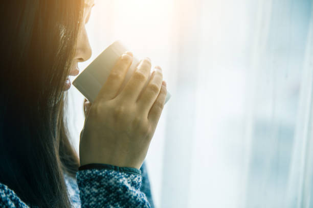 istock beautiful woman holding a cup 902203496
