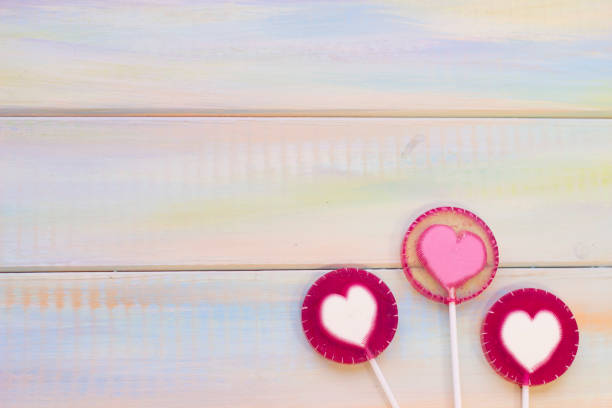 istock St. Valentine's wooden background with lolipops 902203876