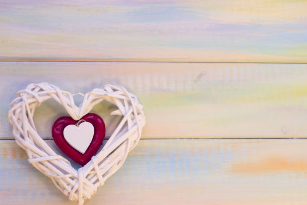 istock St. Valentine's wooden background with woven heart 902207128