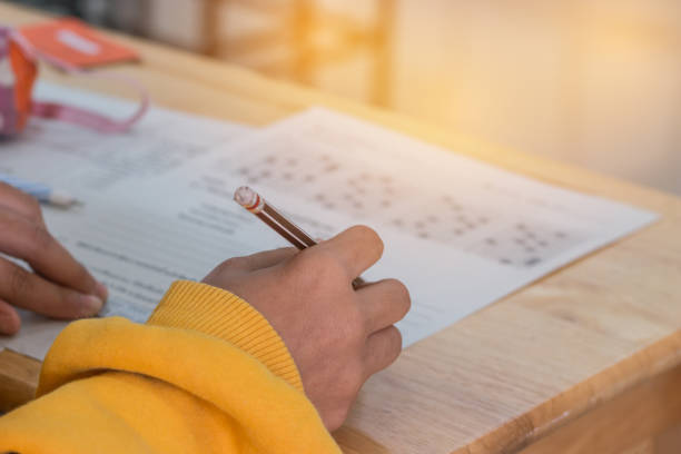 Students concentration holding pencils in hand doing multiple-choice quizzes testing exams answer sheets exercises in school, Tests is concept assessment intended to measure knowledge skill aptitude lápices de holding de concentración de estudiantes en mano haciendo cuestionarios de opción múltiples pruebas exámenes contestar ejercicios de hojas en la escuela, pruebas es concepto evaluación destinada a medir la aptitud de conocimientos habilidades