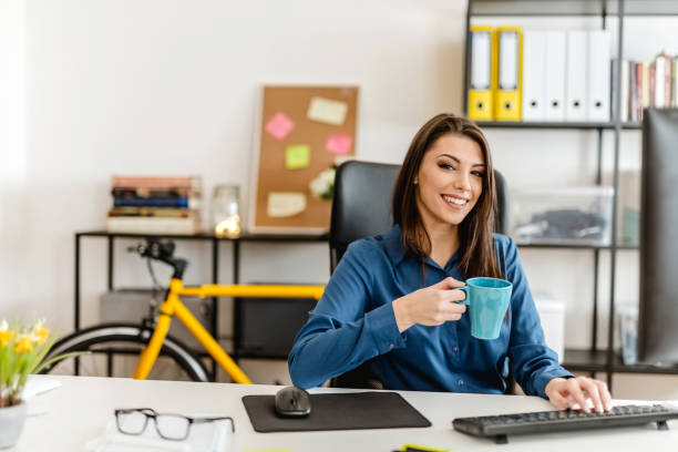 istock Young woman in her office, working and drinking coffee 902212814