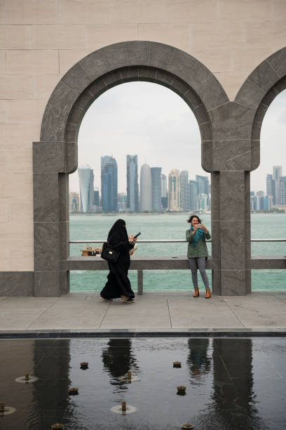 doha, カタールの携帯電話で 2 人の女性 - museum of islamic art doha ストックフォトと画像