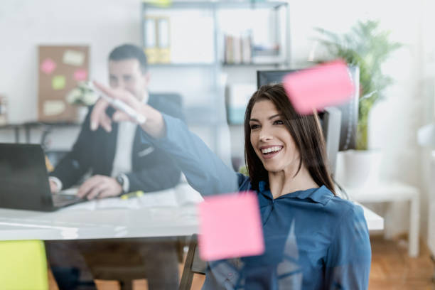 istock Young woman writing on a glass wipe board 902214986