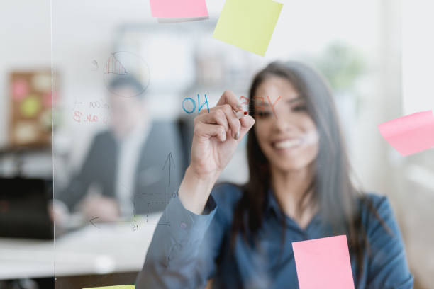 istock Young woman writing on a glass wipe board 902217542