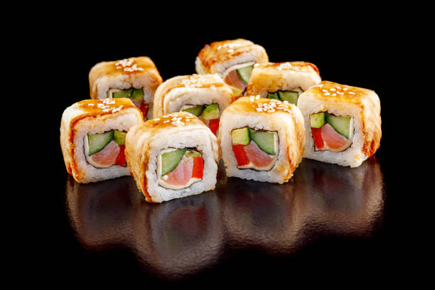istock Fresh vegetable sushi rolls with salmon on a black background. 902217788