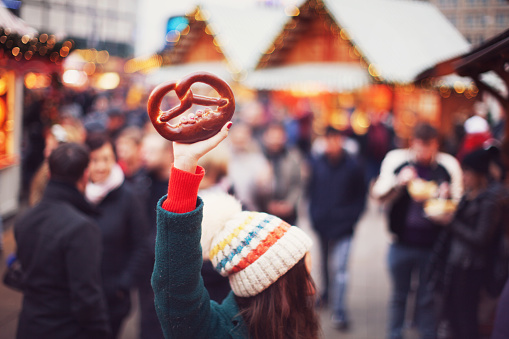 Young woman with pretzel at Christmas market in Berlin