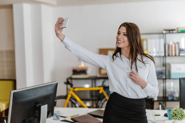 istock Young woman taking a selfie in the office 902220758
