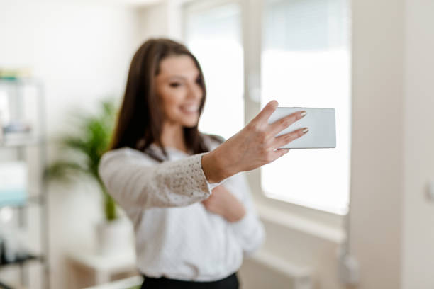 istock Young woman taking a selfie in the office 902220972