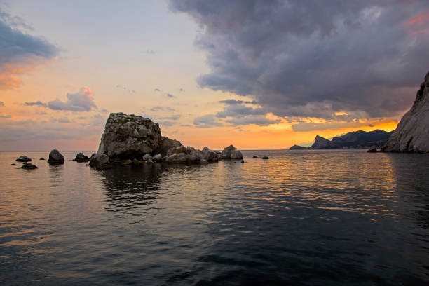 Sunset on the Black Sea coast. View from the embankment of Sudak in the direction of Novyy Svet. Crimea, September.