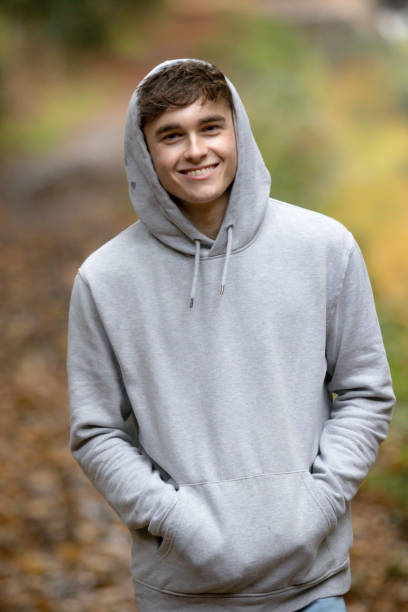 Teenage boy walking alone on an atumn day A young adult male walking alone outside on an autumn day secondary school activities stock pictures, royalty-free photos & images