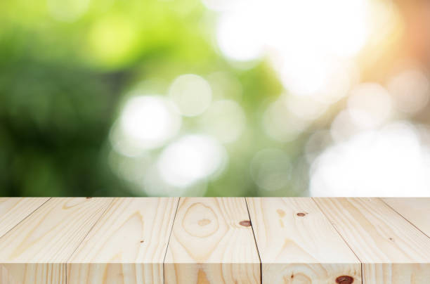 istock wood shelf on blurred green leaves background 902221596
