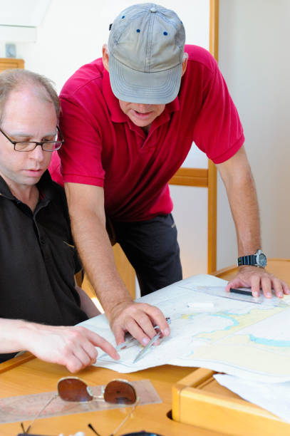 segellehrer und schüler arbeiten mit navigationskarte - nautical chart drawing compass map old stock-fotos und bilder