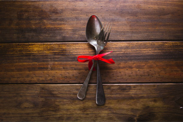 istock spoon and fork with a red bow on a wood background 902252246