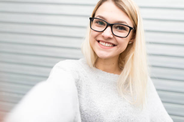 istock Beautiful young girl is making selfie 902257856