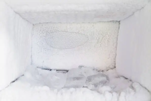 Empty of a refrigerator. Ice buildup inside of a freezer walls.