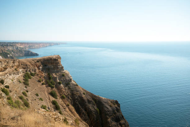 istock High cliff with travelers on the sea 902261076