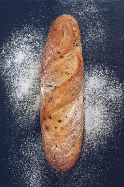 istock The bread with bean flour on the grey surface.The loaf on the stone plate,top view. 902268710