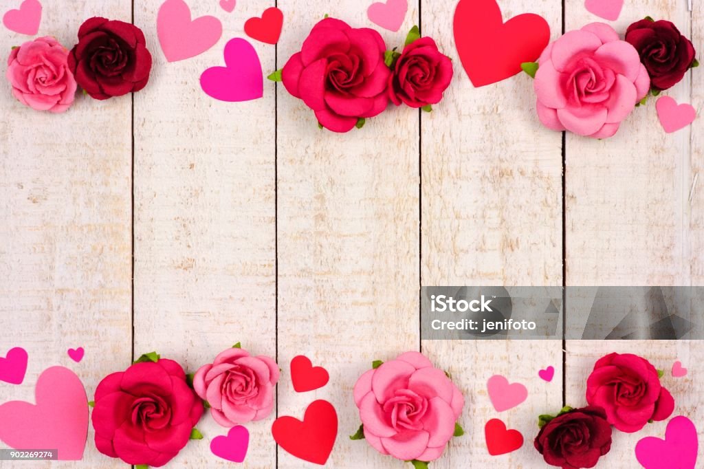 Valentines Day double border of hearts and roses against rustic white wood Valentines Day double border of red and pink paper hearts and roses against a rustic white wood background with copy space. Valentine's Day - Holiday Stock Photo