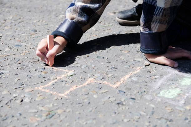 istock Boy drawing on asphalt in spring park, summer activity 902269500