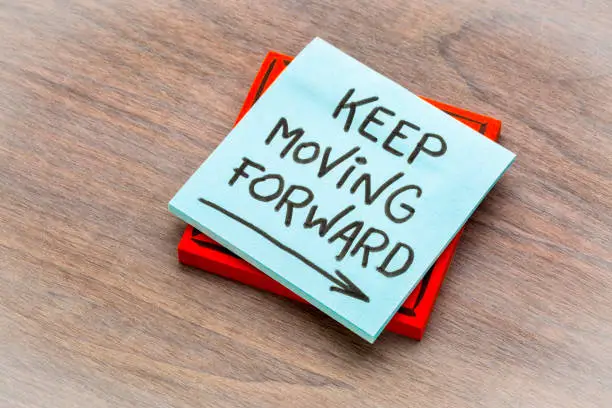 keep moving forward reminder - handwriting on a sticky note