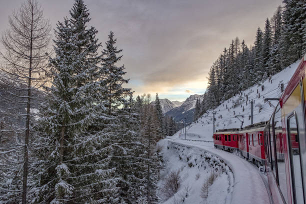 istock Red train in the snow in swiss alps 902276818