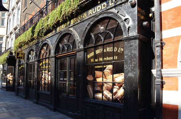 Historic shop of Berry Bros. & Rudd in London View to a historic alley with the shopwindow of Berry Bros. & Rudd with oversized wine corks - London, Great Britain - 08/02/2015 facade store old built structure stock pictures, royalty-free photos & images