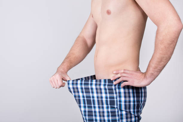 Erektionsprobleme Symbolic posture in pajama pants penis photos stock pictures, royalty-free photos & images