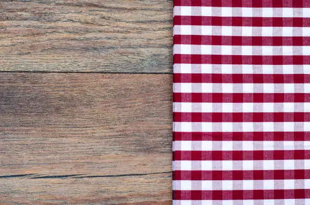 Photo of Tablecloth in white and red cage on wooden table